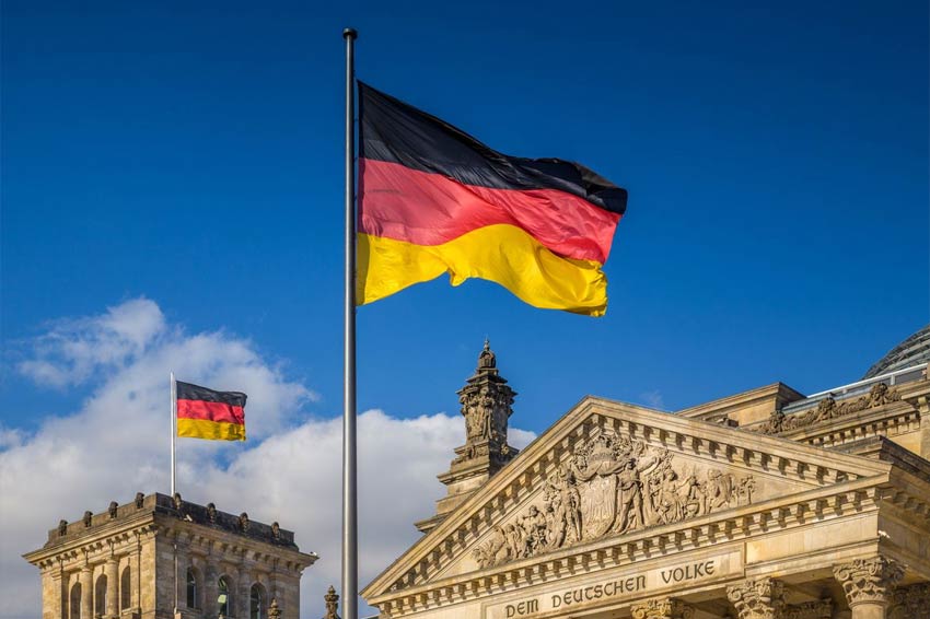 german flags waving in wind at reichstag building