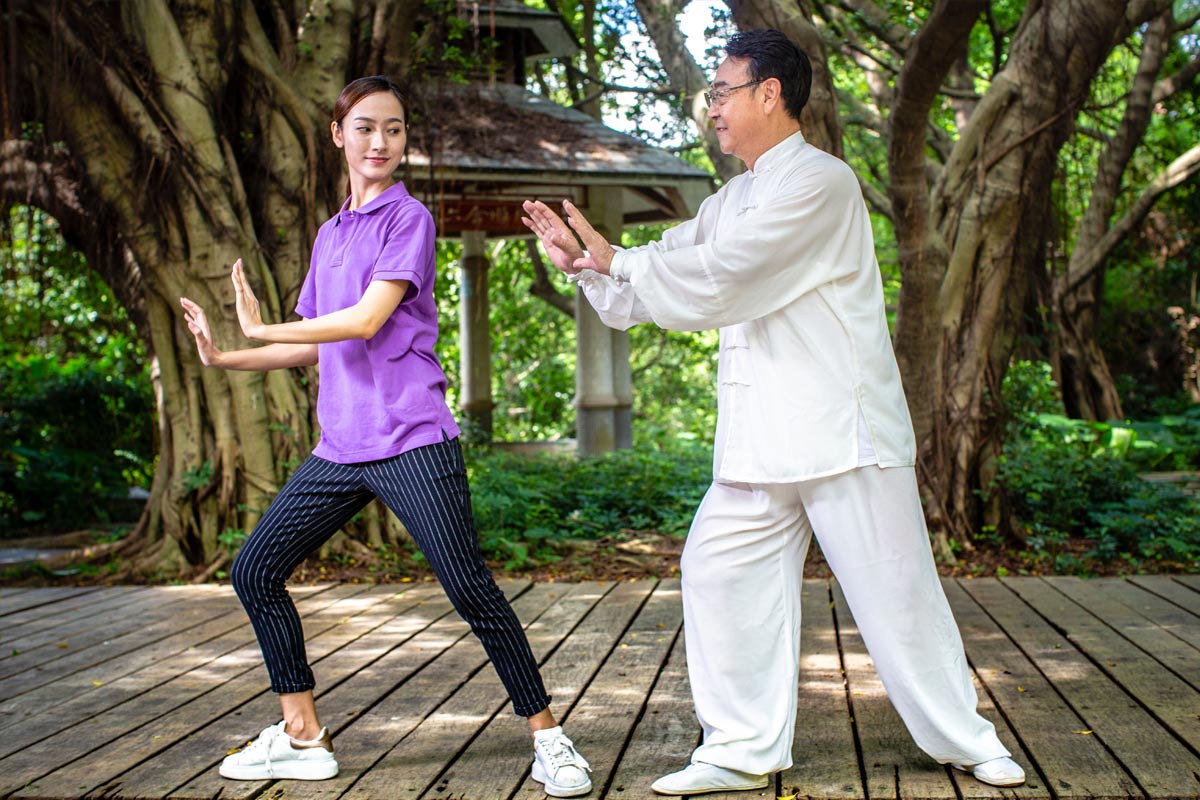 Senior man and Home Instead Caregiver engage in martial arts training outside