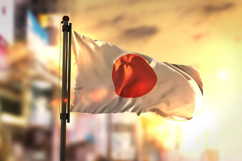 Japan flag waving against blurred city and sunset background